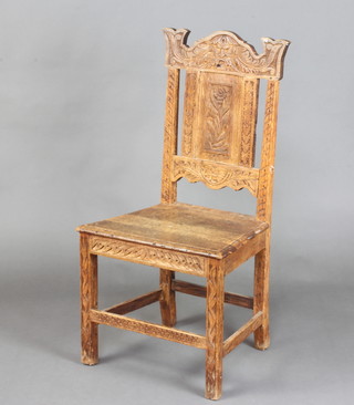 A Victorian carved oak hall chair with solid back, the crest carved The Green Man, raised on square carved supports 