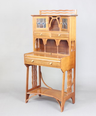 An Art Nouveau Liberty style mahogany bureau, the upper section with a recess and cupboard enclosed by lead glazed panelled doors, above 2 drawers with a recess below, the baised flip over base fitted a drawer with undertier 139cm h x 64cm w x 39cm 
