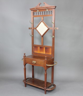 An Edwardian Art Nouveau mahogany hall stand with broken pediment, diamond shaped bevelled plate mirror and tiled  back, the  base fitted a drawer and 2 umbrella/walking stick stands to the sides complete with drip trays 195cm h x 92cm w x 33cm d  
