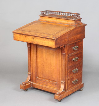 A Victorian oak Davenport desk, the stationery box with 3/4 gallery and bobbin turned decoration, the writing front inset a brown leather writing surface above 4 long drawers 87cm h x 57cm w x 57cm d 