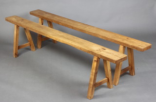 A pair of 19th Century cherry trestle benches, raised on outswept supports 50cm h x 200cm l x 17cm w 