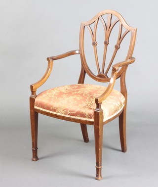 An Edwardian Hepplewhite style inlaid mahogany shield back open arm chair with over stuffed seat, raised on square tapered supports ending in spade feet (old repair to left hand arm) 