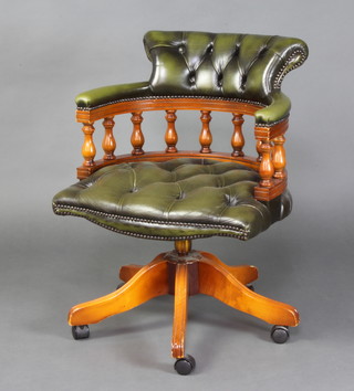 A yew tub back revolving office chair, the seat and back upholstered in green buttoned leather 