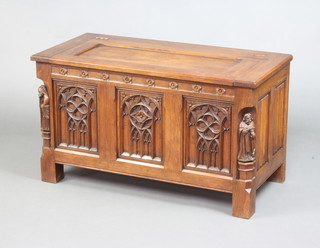 An oak coffer with hinged lid and carved figure decoration to the sides and carved panels to the front 50cm h x 86cm w x 41cm d 
