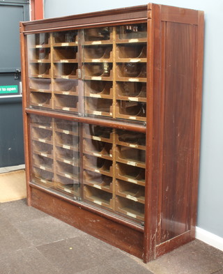 A Pollards Patent Kwikserving mahogany and plywood drapers display cabinet with moulded cornice, the upper section fitted 20 shallow drawers the lower section fitted 20 shallow drawers enclosed by glazed sliding panelled doors 168cm h x 152cm w x 55cm d 
