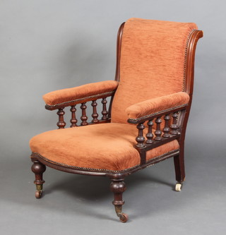 A Victorian show frame mahogany armchair with bobbin turned decoration, upholstered in terracotta material raised on turned supports (some scuffs and contact marks to the sides) 