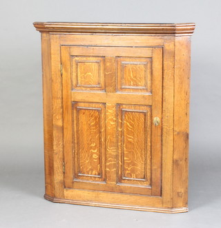 An 18th Century oak hanging corner cabinet fitted shelves enclosed by a panelled door 98cm h x 87cm w x 47cm d 