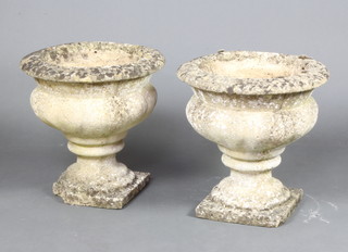 A pair of well weathered circular concrete garden urns raised on square feet 39cm h x 40cm diam. 