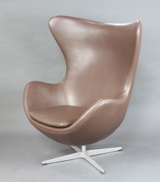 After Arne Jacobsen, an egg chair upholstered in brown leather 106cm h x 78cm w  