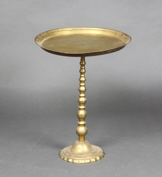 A circular Eastern brass pedestal table raised on bobbin turned supports with spreading foot 50cm h x 38cm diam. together with a brass table lamp 