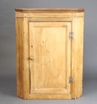 A 19th Century stripped and polished pine corner cabinet with moulded cornice, fitted shelves enclosed by panelled door 102cm h x 77cm w x 42cm d (some old but treated worm) 