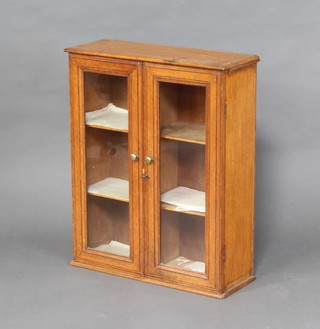 A Victorian light oak hanging display cabinet, fitted shelves enclosed by glazed panelled doors 63cm h x 51cm w x 20cm d 