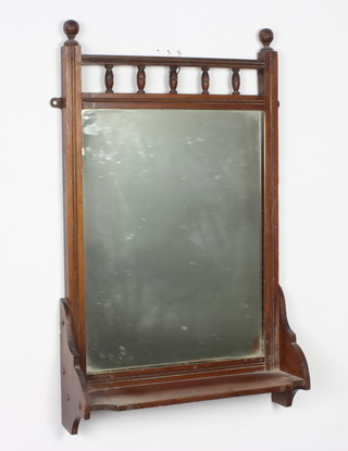 An Edwardian rectangular plate wall mirror contained in a walnut frame with bobbin turned decoration incorporating a shelf to the bottom 68cm h x 41cm w x 13cm d 