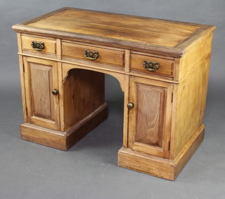 An Edwardian pine dressing table fitted 1 long and 2 short drawers above cupboards enclosed by panelled doors 76cm h x 106cm w x 58cm d (in 1 section, does not come apart) 