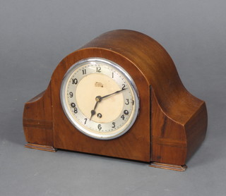 An Art Deco chiming mantel clock with silvered dial and Arabic numerals in a walnut arch shaped case 