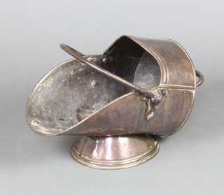A Victorian copper helmet shaped coal scuttle with iron swing handle 