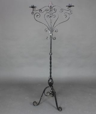 A wrought iron twin light floor standing candelabrum raised on 3 scroll supports 157cm x 64cm x 50cm 