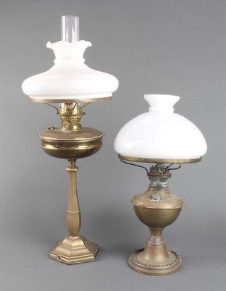 A gilt metal oil lamp raised on a hexagonal column and spreading foot (base drilled) complete with an opaque glass shade and chimney and 1 other 
