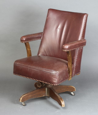 A 1950's revolving office armchair upholstered in brown leather 