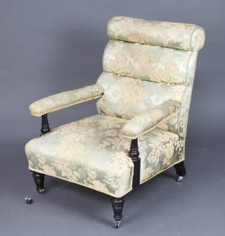 A Victorian turned and ebonised open arm chair upholstered in floral material, raised on turned supports (1 caster f) 