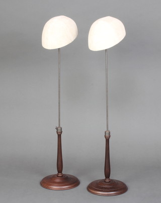 A pair of turned wooden and metal milliner's adjustable display stands, raised on turned bases 58cm h x 20cm x 14cm  