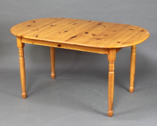 A rounded rectangular pine dining table with concealed extra leaf, raised on turned supports 74cm h x 143cm l x 91cm w 