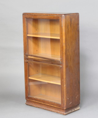 A 1930's oak display cabinet fitted shelves enclosed by a glazed panelled door 106cm h x 61cm w x 25cm d 