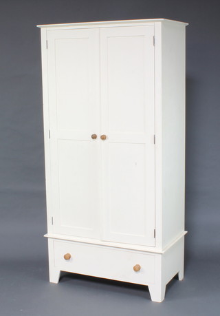 A white painted wardrobe enclosed by a panelled door, the base fitted a drawer, raised on bracket feet 202cm h x 100cm w x 55cm d 