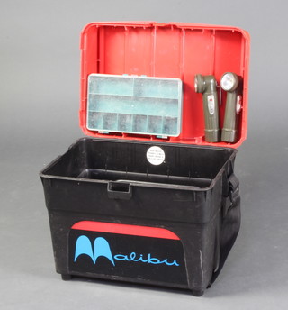 A black and red plastic fishing box seat containing various tackle