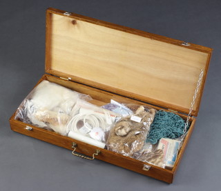 A rectangular wooden box containing a collection of fly tying equipment 