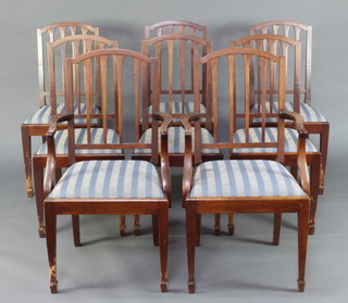A set of 8 Edwardian mahogany stick and rail back dining chairs with upholstered drop in seats raised on square tapered supports, spade feet (most of the legs have been dog chewed)