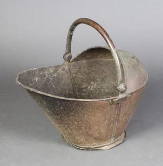 A copper helmet shaped coal scuttle with swing handle
