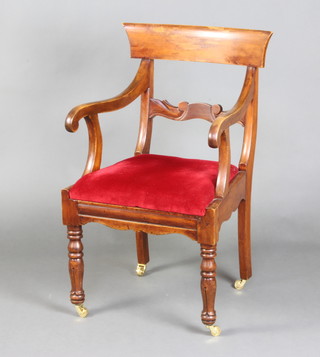 A Georgian mahogany bar back carver/desk chair with shaped mid rail and upholstered drop in seat, raised on turned and fluted supports with brass caps and casters (There is an old break to the top of the left hand leg and some staining to the bar back) 