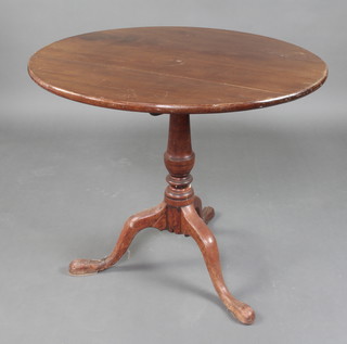 A Georgian circular mahogany snap top tea table, raised on a turned column and tripod base (leg f and r) 71cm h x 80cm diam. (split and ring mark to the top)