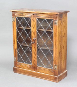 A oak display cabinet, fitted shelves enclosed by  lead glazed panelled doors 86cm h x 72cm 29cm d  