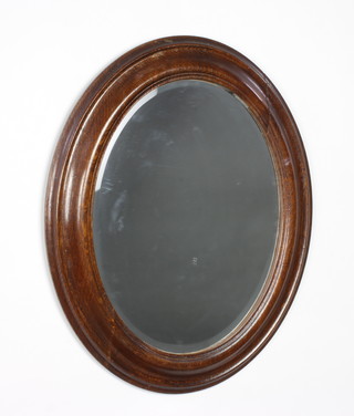 An oval bevelled plate wall mirror contained in an oak frame 57cm x 47cm 