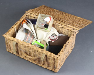 A wicker basket containing a collection of fishing tackle