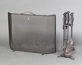 A wrought iron 4 piece fireside companion set and a wrought iron spark guard