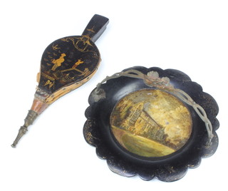 A Victorian circular papiermache dish decorated a country house and with gilt metal swing handle 25cm and a pair of 1930's lacquered bellows 32cm x 3cm (leather perished) 
