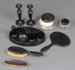 A pair of turned ebony candlesticks with metal sconces 18cm, a circular cut glass powder bowl with turned ebony lid, 1 other and a 12 piece ebony backed dressing table set  