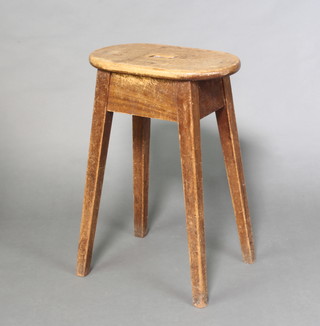 An oval elm stool raised on square outswept supports 67cm h x 46cm w x 28cm d 