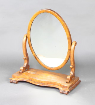 A Victorian oval plate dressing table mirror contained in a mahogany swing frame 