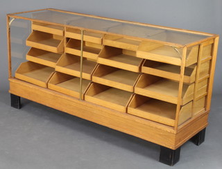 A 1930's rectangular light oak drapers display cabinet fitted 16 graduated drawers, raised on ebonised feet 91cm h x 180cm w x 57cm d  
