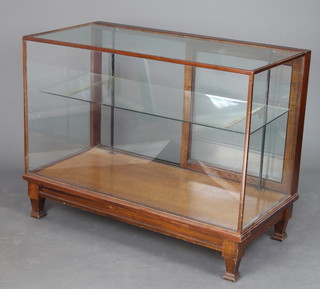 A 1930's rectangular mahogany shop display cabinet fitted a glass shelf, raised on square tapered supports 90cm h x 117cm w x 59cm d 