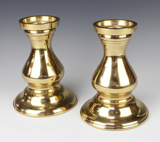 A pair of brass candlesticks raised on bulbous baluster turned bases 21cm h x 16cm d 