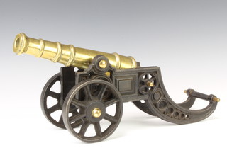 A brass cannon with 28cm barrel and drilled touch point, raised on a pierced iron carriage