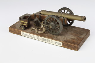 A wooden and brass model of a canon with 15.5cm brass barrel raised on a wooden stand 