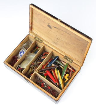 A wooden box containing various lures and hooks 
