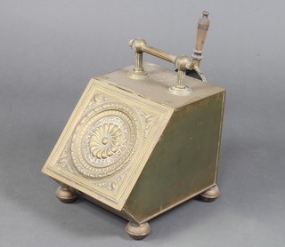 An Art Nouveau embossed brass wedge shaped coal bin complete with shovel, raised on bun feet 30cm h x 27cm w x 36cm d 