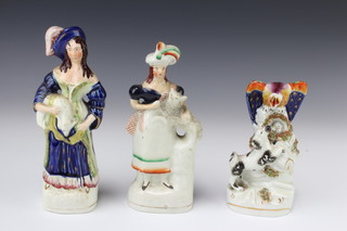 A Victorian Staffordshire group of an eagle protecting its nest with a rising terrier 16cm together with 2 Victorian Staffordshire figures of ladies carrying sheep 22cm and 21cm 